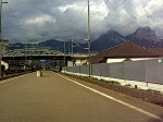 Eine Re4/4 in SwissExpress-Lackierung bei der Einfahrt in den Bahnhof Brunnen.