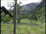 Berner Oberland 2004 (VHS-Archiv) - Ein  Traktor  bringt zwei Flachwagen am 26.05.2004 nach Blausee-Mitholz und in Kandersteg fhrt Re 460 002  Seeland  mit einem EC nach Mailand ein.